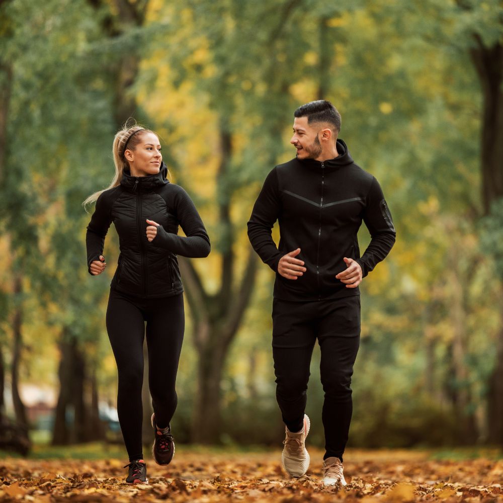 Man and woman jogging outdoors for active lifestyle and daily wellness support