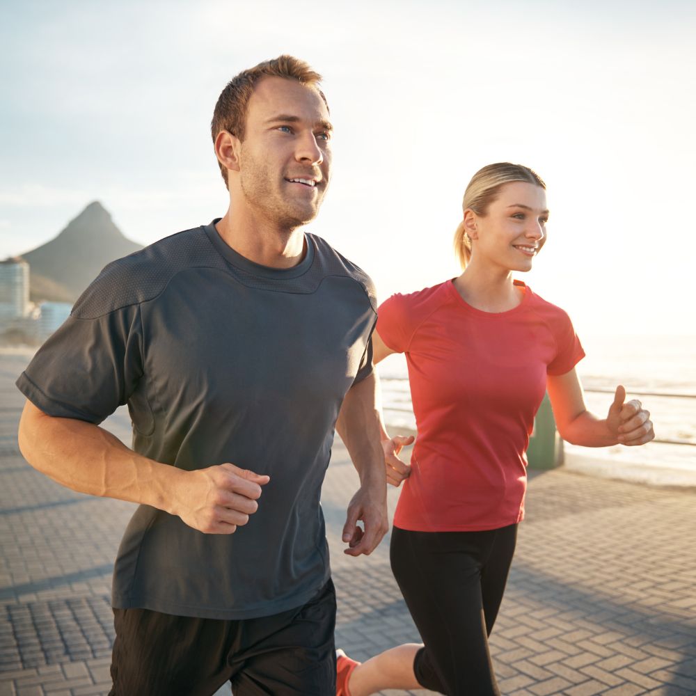 Active couple jogging outdoors for fitness, energy, and healthy lifestyle support