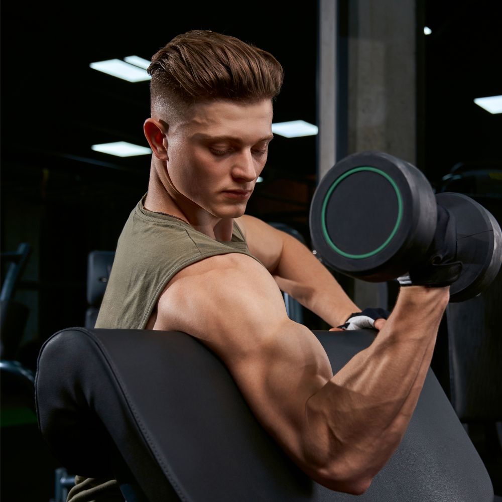 Man lifting dumbbell in gym for strength, muscle growth, and fitness support
